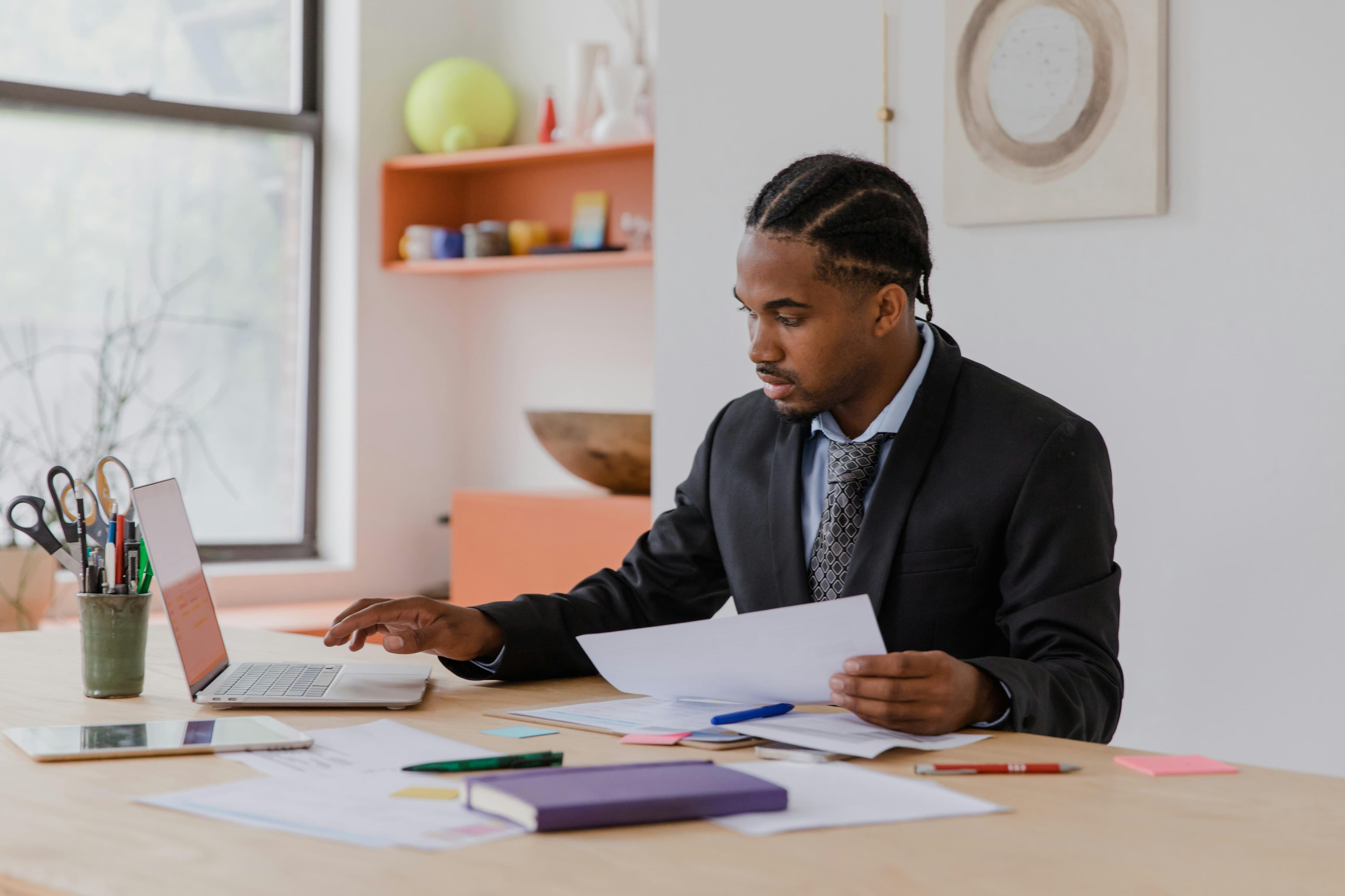 Focused businessman working with laptop and documents in a modern office setting